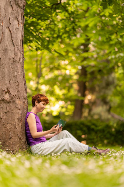 istock LGBT woman with tablet resting near tree 1403176204