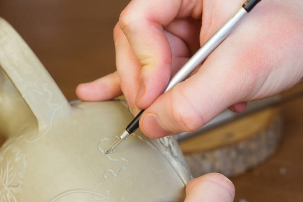 Workers decorate porcelain cups at a ceramics factory in Jingdezhen, China.