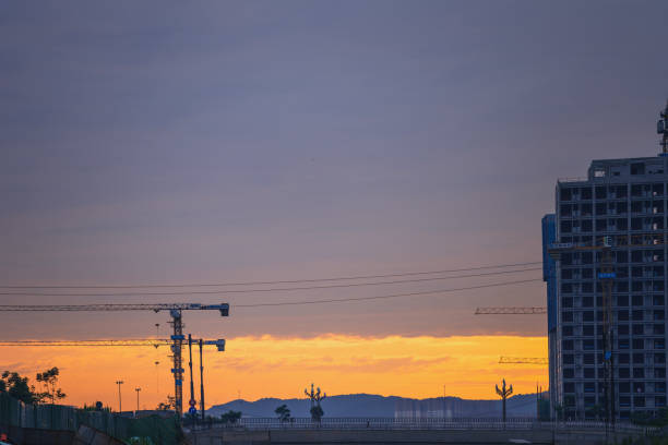 At sunrise time and with a dramatic colorful sky, view of a modern telecommunication tower standing on its own with beautiful cloudscape behind it.