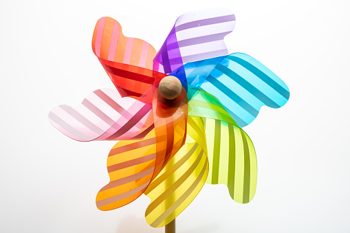 Pinwheel isolated on white background. Rainbow color windmill toy on a wooden stick