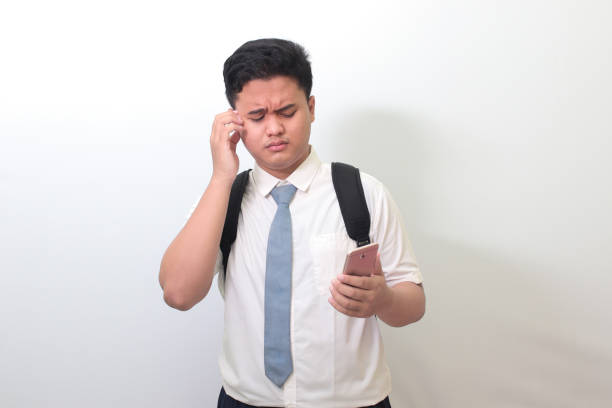 istock senior high school student showing confusion face expression while holding a mobile phone 1403192673