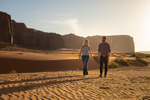 Young couple walking during sunset in Monument Valley park, Utah