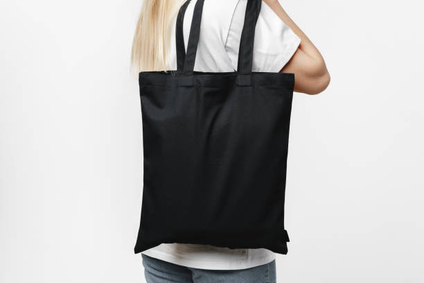 istock Female holding black cotton bag in her hands on white background 1403195067
