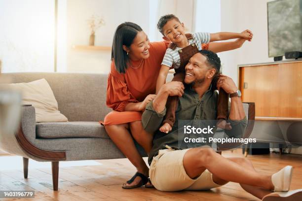 A Happy Mixed Race Family Of Three Relaxing In The Lounge And Being Playful Together Loving Black Family Bonding With Their Son While Playing Fun Games On The Sofa At Home Stock Photo - Download Image Now