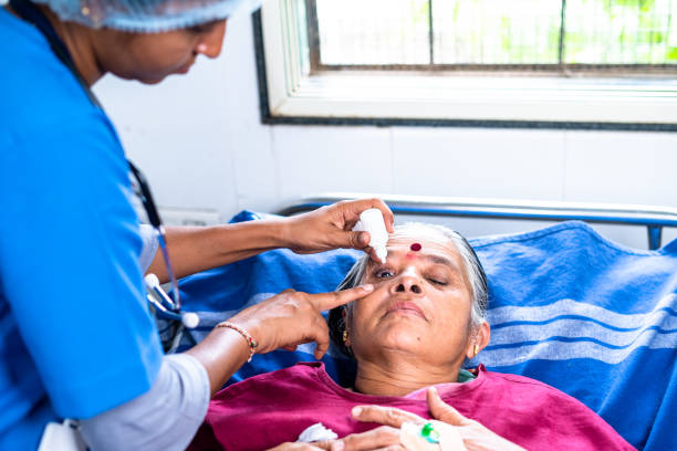 enfermeira pingando gota de pé para paciente sênior enquanto dormia na cama no hospital - conceito de tratamento, cuidado ocular e ocupação profissional - eyesight senior adult care support - fotografias e filmes do acervo