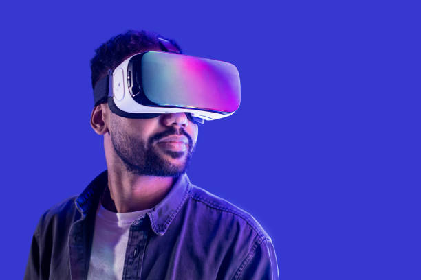 istock Young man using virtual reality eyeglasses headset, isolated on blue background 1403202427