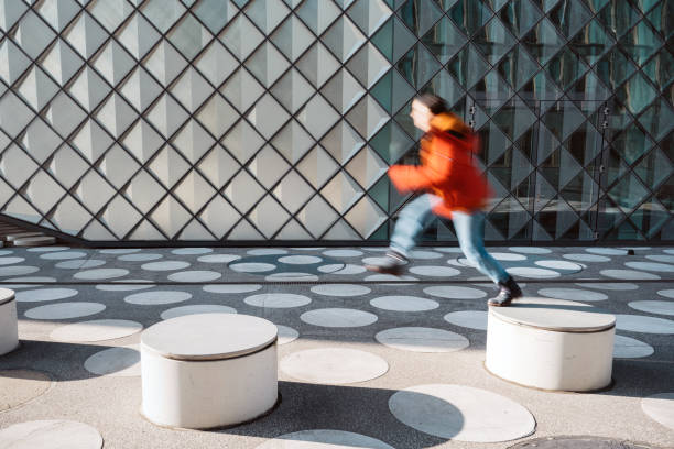 istock motion blurred  woman jumping from bench to bench on white spotted town square 1403203723