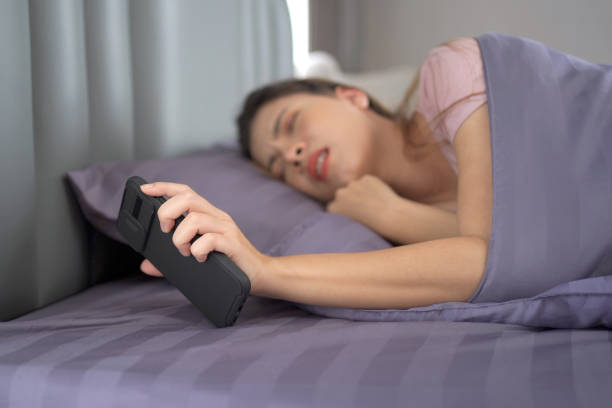 istock Woman snoozing an alarm clock on smartphone. 1403206010