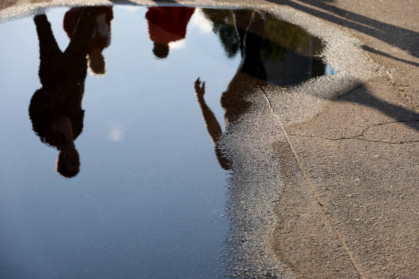 istock Defocused view to people reflection in puddle on a street 1403208337