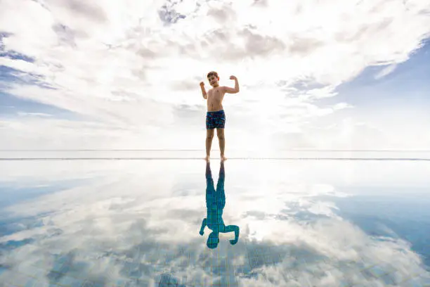 Photo of Little kid on a pools edge with a cloudly sky background