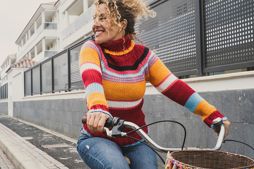 Happy mature young woman riding a bike and smiling enjoying outdoor active healthy leisure activity. Green ambien and environment way of transport with female people using bicycle
