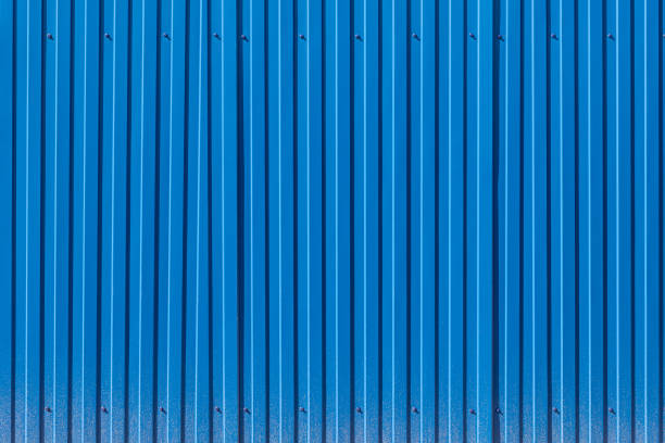 ogrodzenie wykonane z niebieskiej profilowanej blachy z rozpryskami błota w dolnej części - corrugated iron zdjęcia i obrazy z banku zdjęć