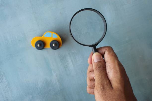 Car inspection, search, looking for car concept. Hand holding magnifying glass and toy car. Car inspection, search, looking for car concept. car transporter truck small car stock pictures, royalty-free photos & images