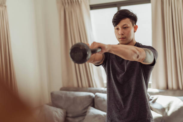 Fit man in sportwear doing exercise with kettlebell at home. Young man workout at home. Fit man in sportwear doing exercise with kettlebell at home. Young man workout at home. Body Weight stock pictures, royalty-free photos & images