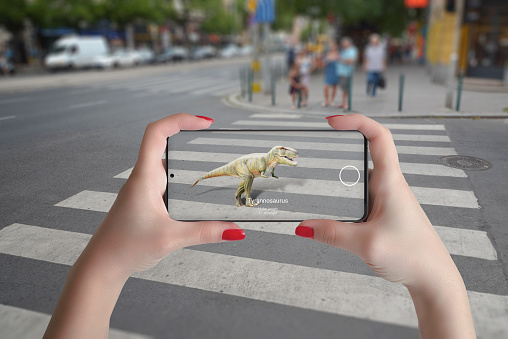 Proyección 3D de dinosaurios en la calle con teléfono inteligente y concepto de tecnología de realidad aumentada photo