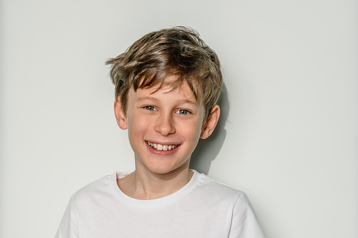 Close up portrait of a cute little boy smiling at the camera outdoors