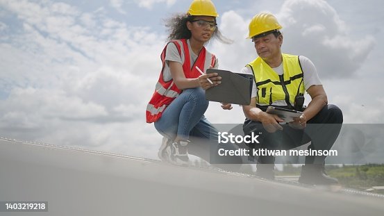 istock African American female engineer and asian male technicians working together in solar power plant. Check to installation or preventive maintenance system of solar panel for electricity produced for factory. Industrial of power generation from solar energy 1403219218