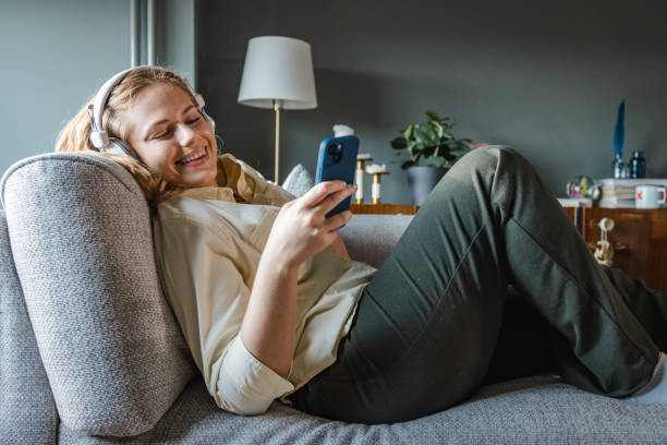 istock Young woman relaxing on the sofa and using smart phone 1403223278