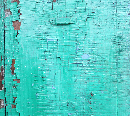 Wooden surface with cracked green paint texture