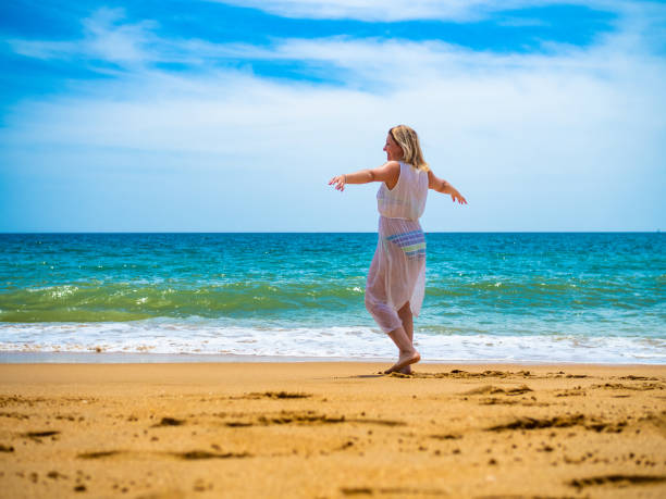 istock Beautiful woman walking on beach 1403224879