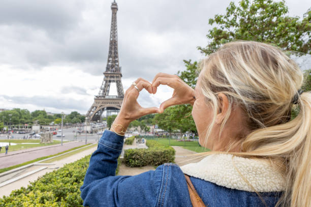 istock Young woman in Paris makes heart on the Eiffel Tower 1403226677