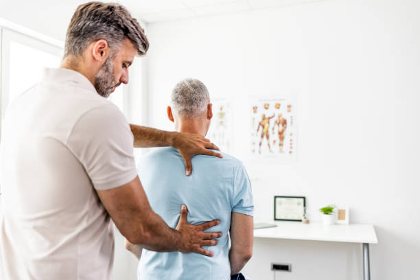 hombre maduro con ajuste quiropráctico de la espalda. - chiropractic adjustment fotos fotografías e imágenes de stock