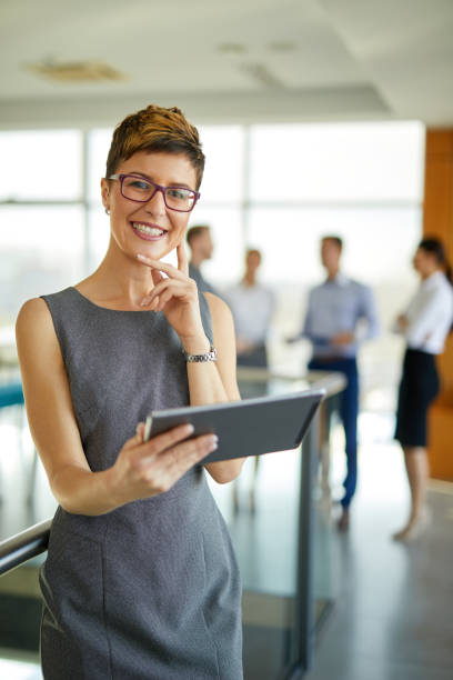istock Young businesswoman using digital tablet in office building hallway 1403228180