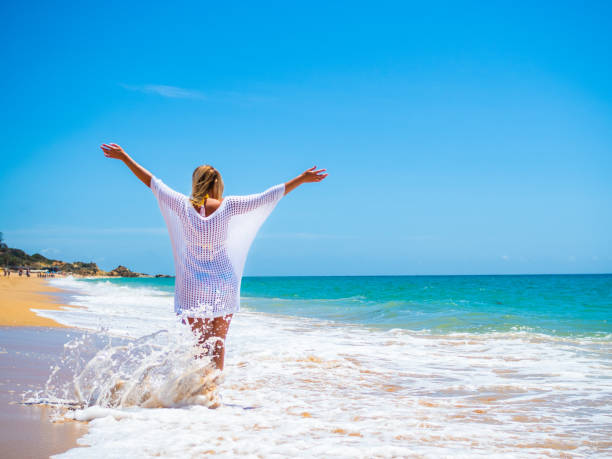 istock Beautiful woman walking on beach 1403228236
