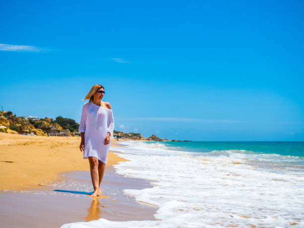 istock Beautiful woman walking on beach 1403228278