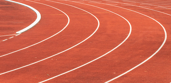 close up of a curved red athletics track in a sports facility