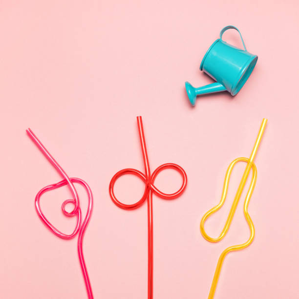 istock Blue watering can is watering multicoloured straws. Summer concept. 1403230079