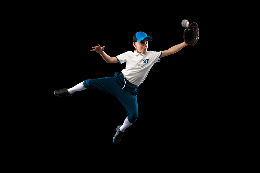 Powerful shot, serve. Professional baseball player in motion, action during match at stadium over blue evening sky with spotlights. Concept of movement and action, sport lifestyle, competition