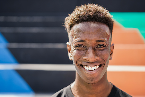 Happy African man smiling at camera outdoor - Focus on face