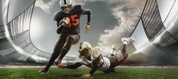 zwei american-football-spieler in aktion, bewegung. sportler kämpfen abends im überfüllten stadion im überfüllten stadion um den ball - receiver stock-fotos und bilder