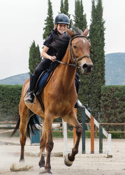 istock Kid on horse jumping over barrier. 1403238068