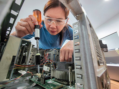 The shot of a a computer technician working to repair computer  in casual clothing.