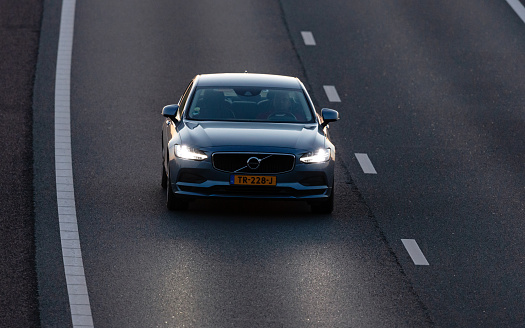 Wierden, Twente, Overijssel, Netherlands, june 11th 2022, close-up of a Dutch 2018 Volvo S90 station wagon approaching on the highway A35 at Wierden at sunset - the A35 is a two lane motorway connecting Enschede with Wierden - the S90 is an executive sedan made by Swedish automaker Volvo Cars since 2016