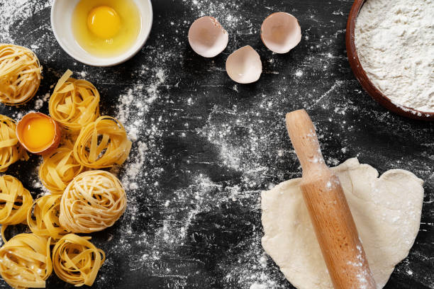 istock Raw egg pasta with flour on black background 1403239567