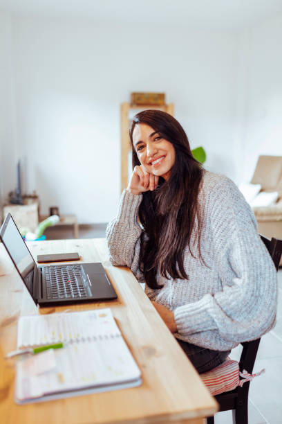 istock Beautiful young woman working in home office looking at camera 1403240136
