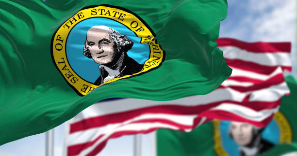 The Washington state flag waving along with the national flag of the United States of America stock photo