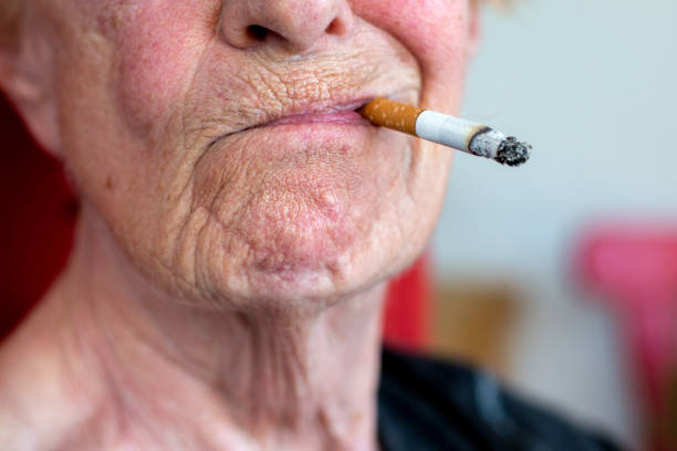 close-up of an old woman smoking a cigarette close-up of an wrinkled old woman smoking a cigarette smokers wrinkles stock pictures, royalty-free photos & images