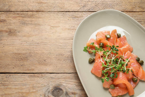 istock Delicious salmon carpaccio served on wooden table, top view. Space for text 1403247788