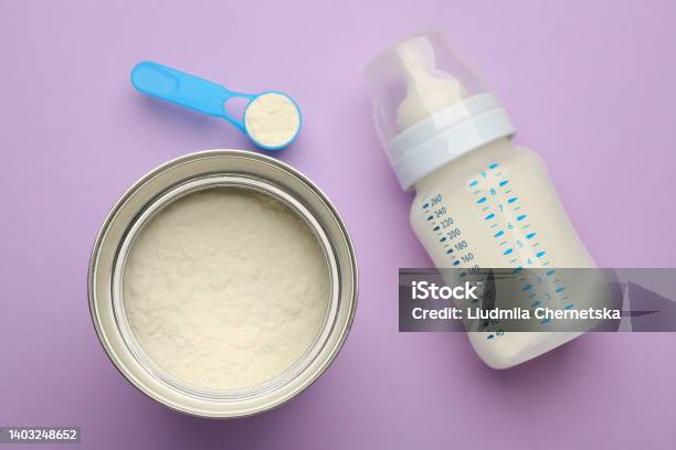 Feeding Bottle With Infant Formula And Powder On Violet Background Flat Lay Stock Photo - Download Image Now