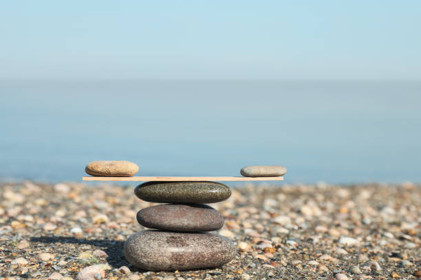 istock Stack of stones with wooden stick on beach, space for text. Harmony and balance concept 1403249240
