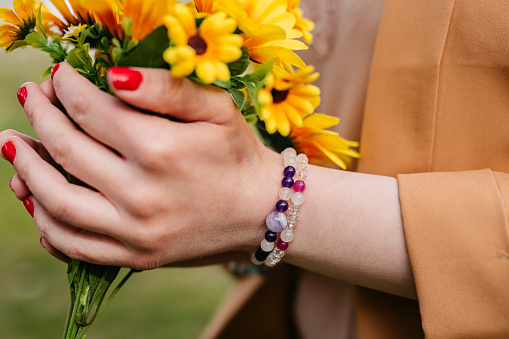 Close-up of a young woman holding flowers in the park.