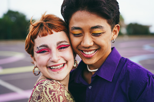 Jóvenes amigos diversos divirtiéndose al aire libre - Concéntrese en un chico asiático gay con maquillaje photo