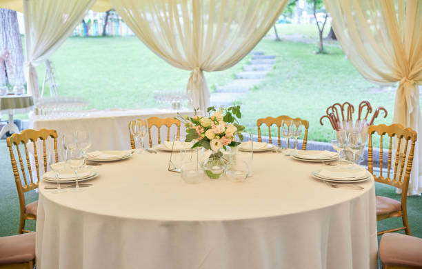 istock Table setting with blank guest card, plates with napkins and cutlery, copy space. Place setting at wedding reception. Round table served for banquet in restaurant 1403250320