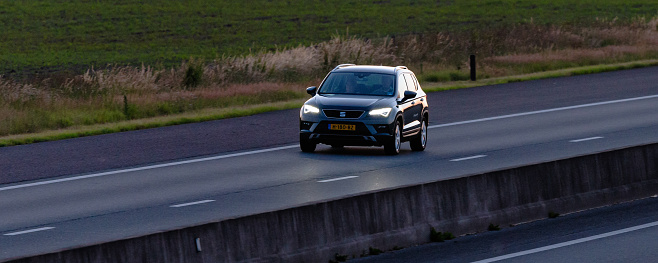Wierden, Twente, Overijssel, Netherlands, june 11th 2022, close-up of a Dutch  2020 SEAT Ateca SUV approaching on the highway A35 at Wierden at sunset - the A35 is a two lane motorway connecting Enschede with Wierden - the Ateca is an SUV made by Spanish carmaker SEAT S.A. since 2016