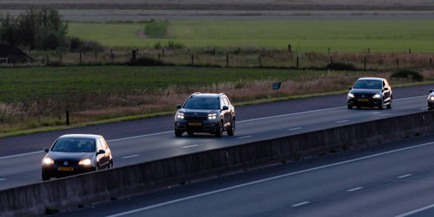 traffic (vw golf, citroen c5, vw polo) approaching on the a35 at sunset - hatchback volkswagen golf volkswagen side view imagens e fotografias de stock