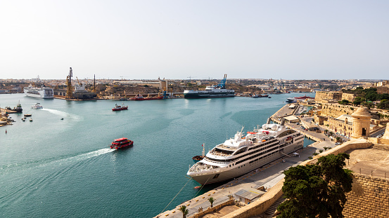 Valletta, Malta - Sep 27, 2021: The beautiful harbor in Valletta with turquoise water and several ships, including a large cruise ship
